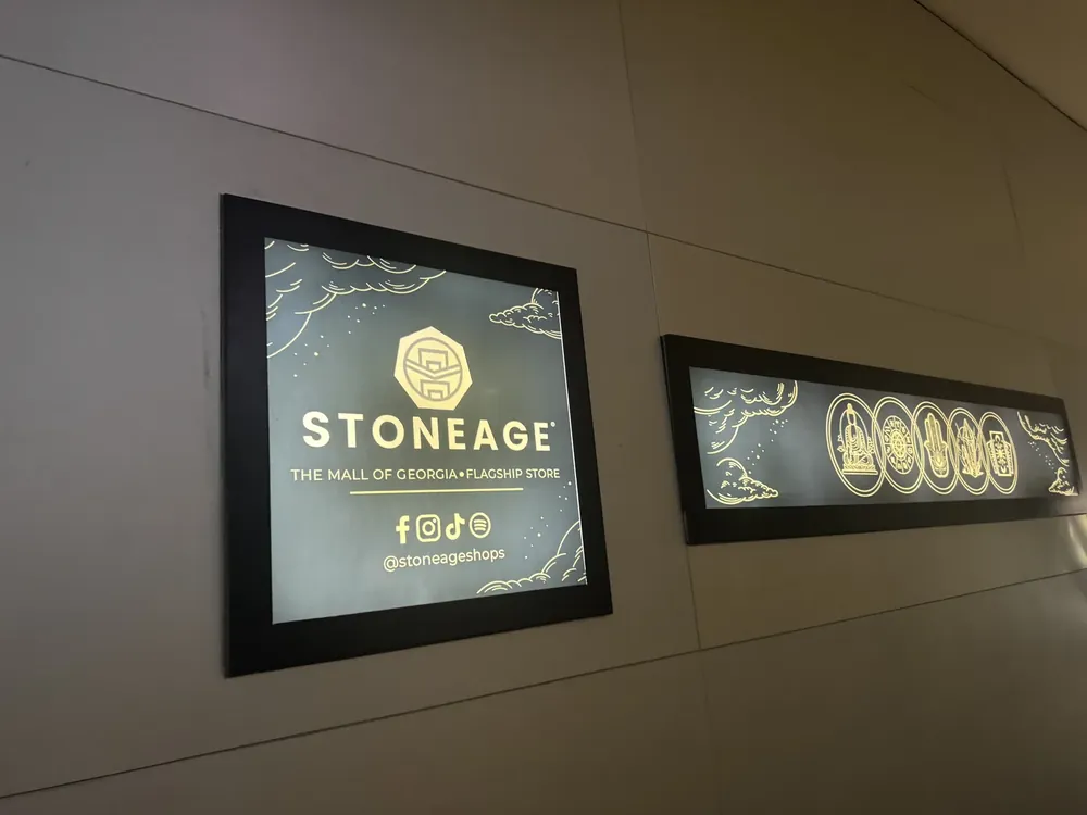 Backlit Stoneage panels in a mall corridor